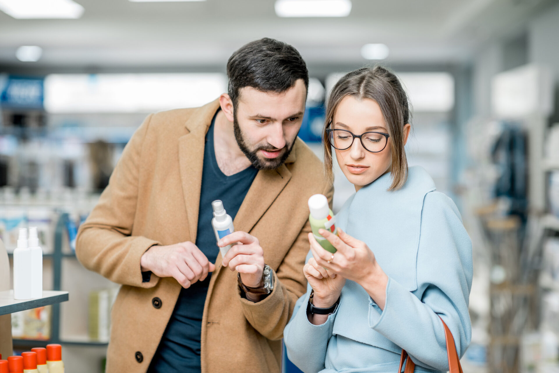 Couple choosing medicine in the pharmacy store Young couple choosing sunscreen standing pharmacy store