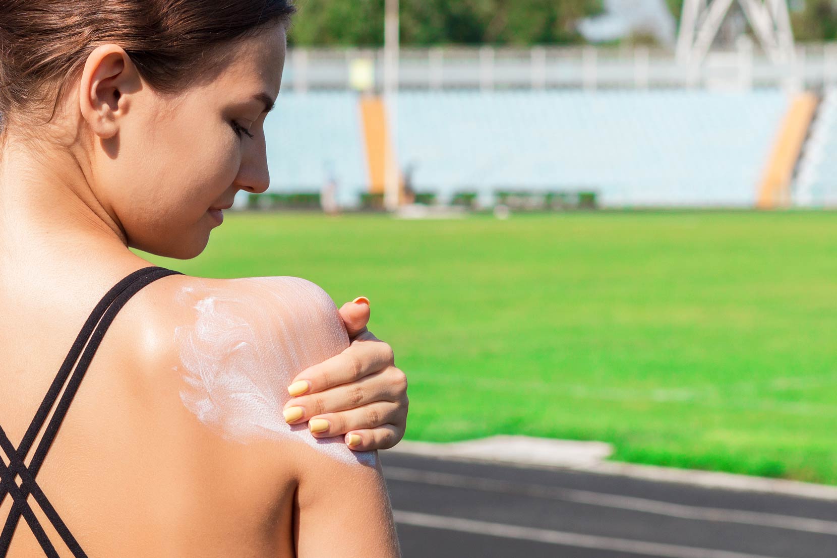 sunscreen-applied-on-woman-shoulder woman applying sunscreen on shoulder